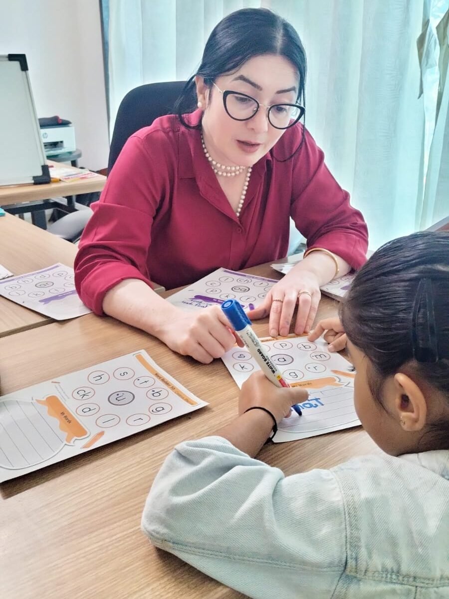 Educator helping a child with learning activities at OM Learning World